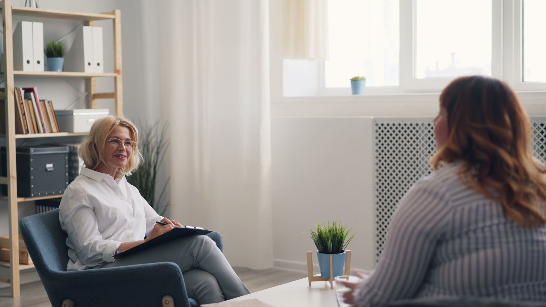 A psychiatrist in conversation with a patient. The scribe runs unattended.